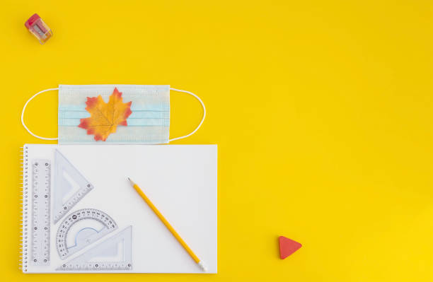 istock sketchbook, ruler, triangle, protractor, pencils, face mask, eraser on yellow background, back to school concept 1254272466