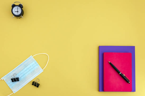 istock workbooks, pen, watch, face mask on yellow background 1254272489