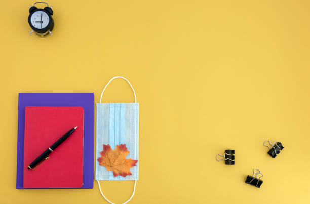 istock workbooks, pen, watch, face mask on yellow background 1254272491