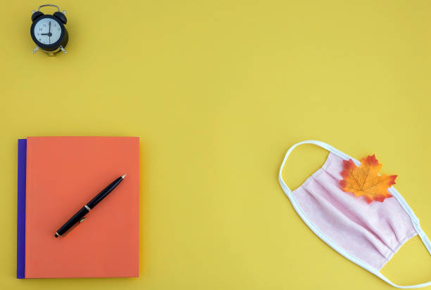 istock workbooks, pen, watch, face mask on yellow background 1254272504