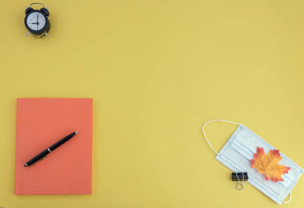 istock workbooks, pen, watch, face mask on yellow background 1254272508