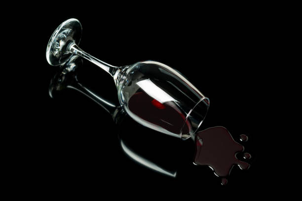 istock Spilled wine glass on a black background with reflection. Alcohol abuse concept. 1254272678