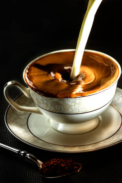 Milk pouring in a cup with coffee