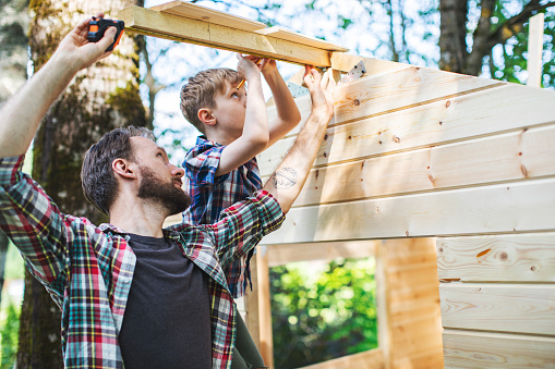 Father and son building tree house at backyard