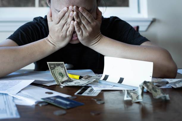 Stressed woman worrying about financial debt and monthly bills. Money crisis. person sitting on the table at home with scattered bills, credit card, loose money changed, tying to figure out out to pay all her monthly bills money cry stock pictures, royalty-free photos & images