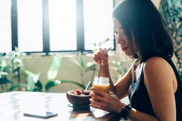 young woman eating heathy vegan breakfast in the morning - food vegan food gourmet vegetarian food imagens e fotografias de stock