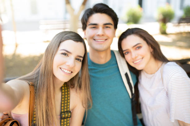 istock Smiling Young Friends Taking Selfie In Park 1254279286