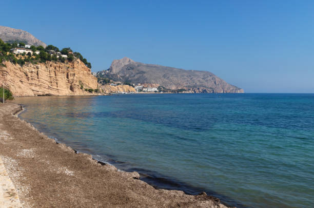 istock Tranquil stone beach with view on rocky cliffs, Altea, Costa Blanca, Spain 1254280943