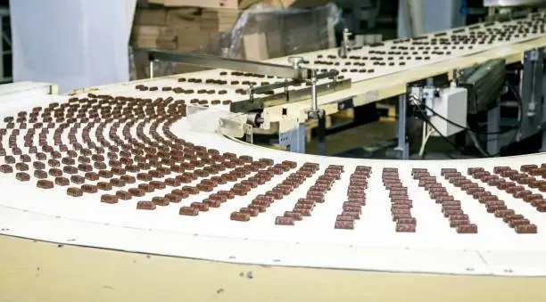 Sweets factory. Sweets production process. Conveyor belt with sweets on it.