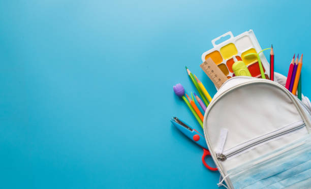 istock White children's backpack with school supplies, office supplies on a blue 1254287101
