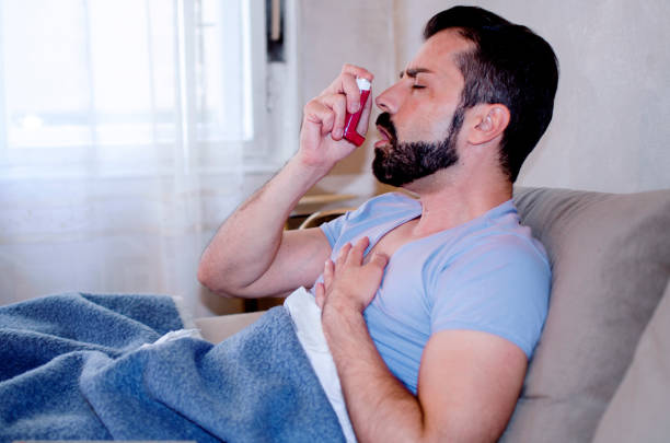 istock Man uses an inhaler during an asthma attack 1254293617