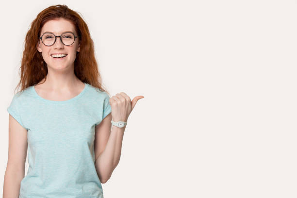 istock Smiling young woman pointing on blank copy space. 1254296707