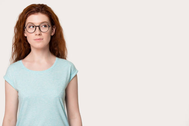 istock Pensive young girl isolated on white grey studio background. 1254296718