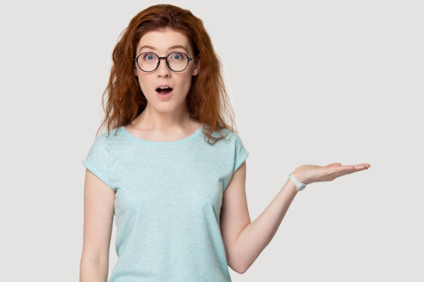 istock Surprised millennial red-haired woman demonstrating free copy space. 1254296726