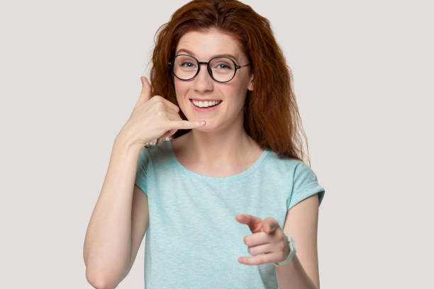 istock Millennial happy woman making call you gesture. 1254296738