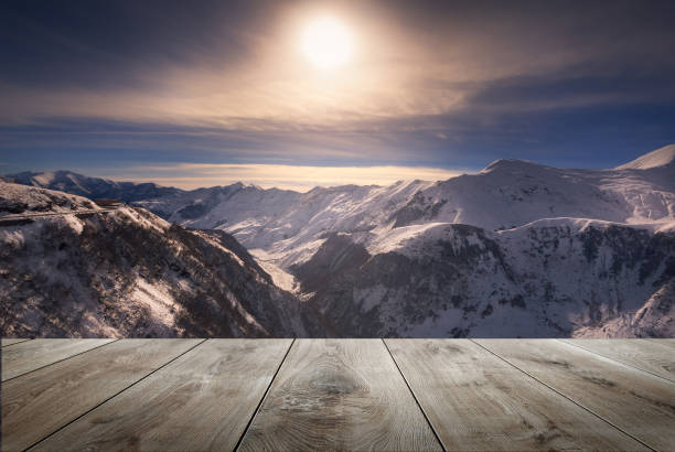 wintersonnenuntergang über kaukasus-bergen mit leerem holztisch. natürliche vorlagenlandschaft - snow winter mountain horizon over land stock-fotos und bilder