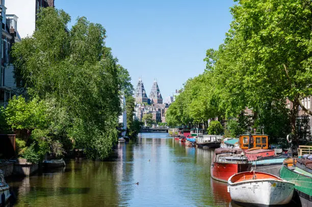 Tree lined canal with view of Rijksmuseum in the centre of Amsterdam, Netherlands.