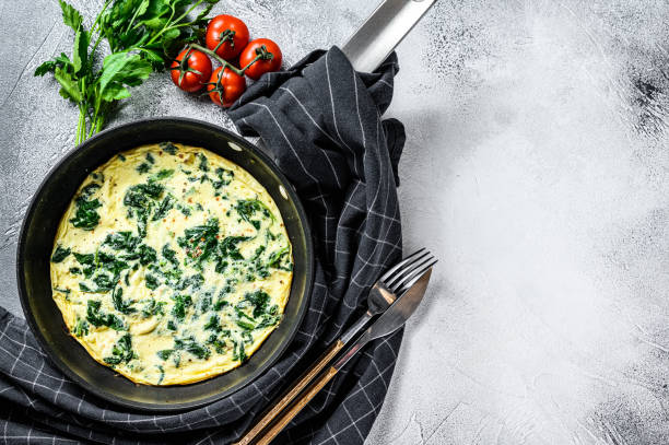 istock Spinach cheese frittata in a pan. Gray background. Top view. Copy space 1254303013