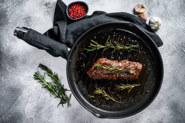 Grilled skirt, machete steak in a frying pan. Marble meat beef. Gray background. Top view Grilled skirt, machete steak in a frying pan. Marble meat beef. Gray background. Top view. blade roast stock pictures, royalty-free photos & images