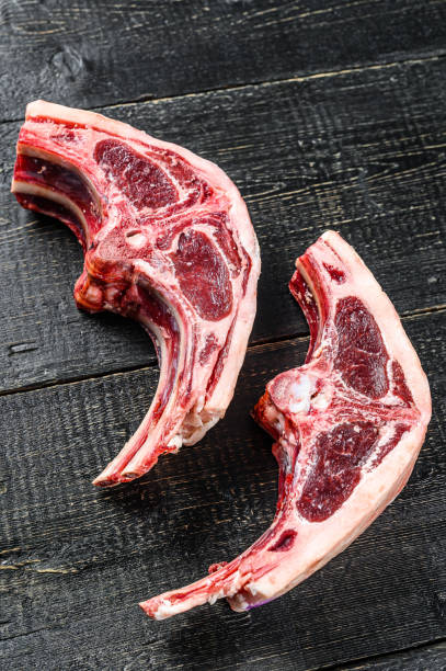 istock Raw lamb cutlets fresh cut . Black background. Top view 1254305209