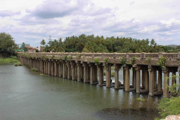 A beautiful view of the famous Lushington Wellesley stone bridge upon river Cauvery built by the British army in 1800s against the clouds in Srirangapatna town near Mysore in Karnataka state of India.