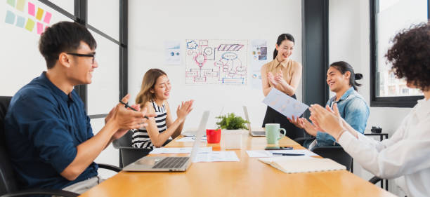 istock Asian business people clapping hands/applause  while meeting for success in modern office, casual clothing 1254310171
