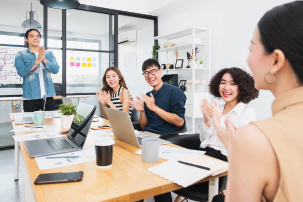 istock Asian business people clapping hands/applause  while meeting for success in modern office, casual clothing 1254310207