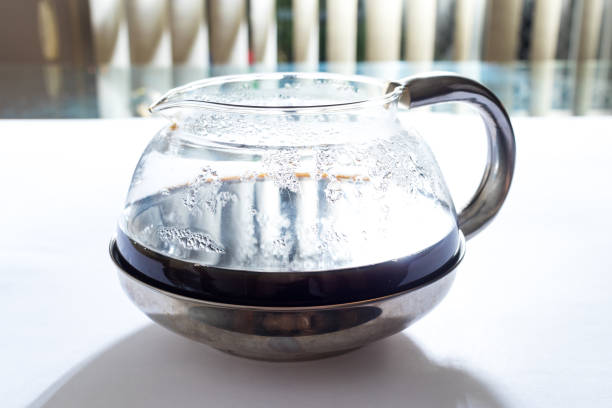 istock Glass teapot with fresh coffee on glass table with shutter in the background 1254311870