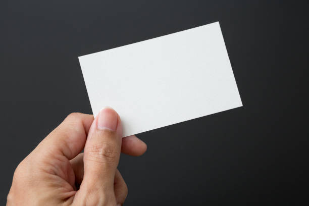 istock Hand holding Business card on a black background 1254323273