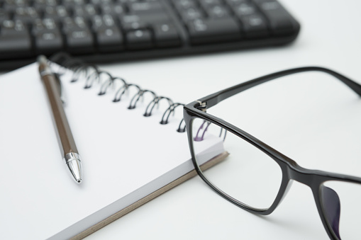 Selective focus of Notebooks, pens, glasses, Keyboard computer on white background and copy space