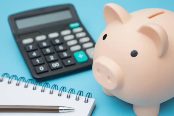 istock Notebooks, Piggy bank, calculator, pens on blue background and copy space 1254323287