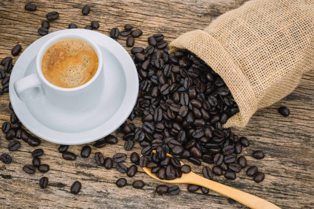 istock Coffee cup and coffee beans roasted in a sack on a wooden floor. 1254323409