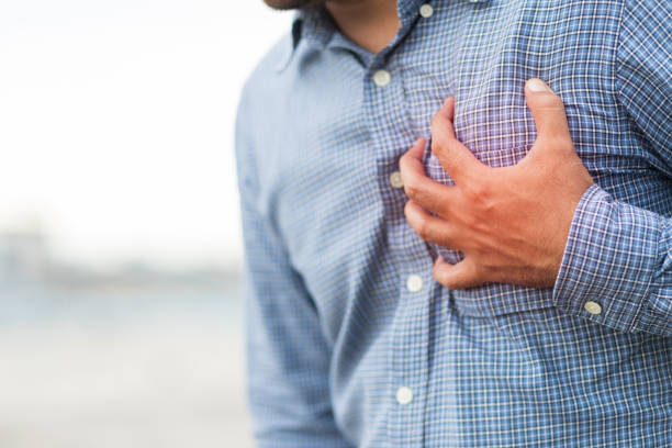 mano hombre en el pecho, apretando su corazón tuvo un ataque cardíaco repentino. - human hand help pain heart attack fotografías e imágenes de stock