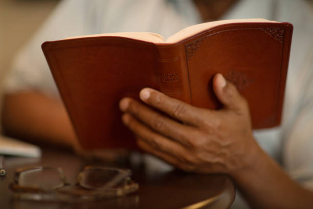 istock African American man praying and reading the Bible. 1254329207