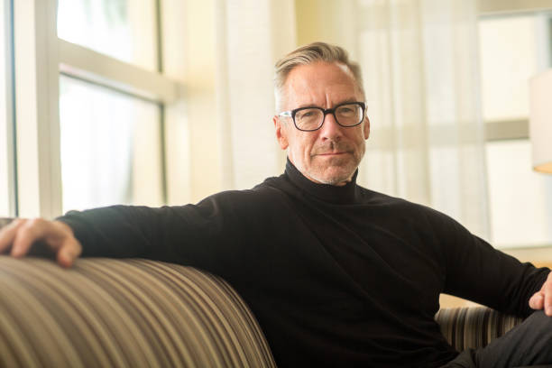 istock Portarit of a handsome older man sitting on a sofa 1254329291