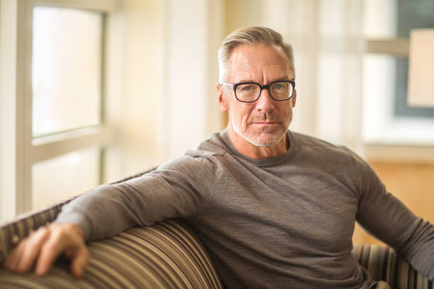 istock Portarit of a handsome older man sitting on a sofa. 1254330080