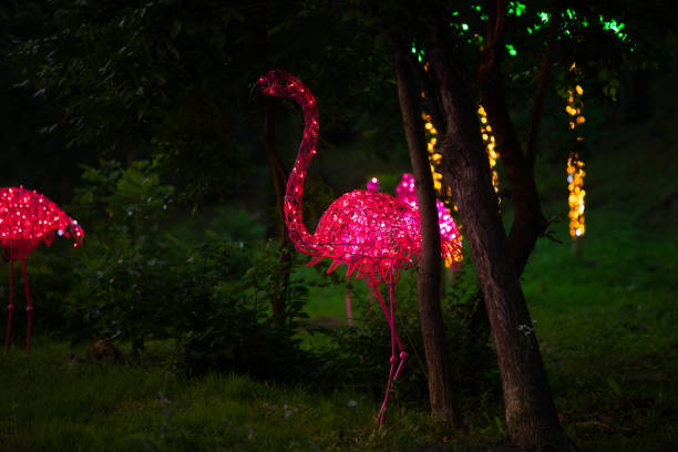 istock Decorative pink flamingo glows in a night park 1254339242