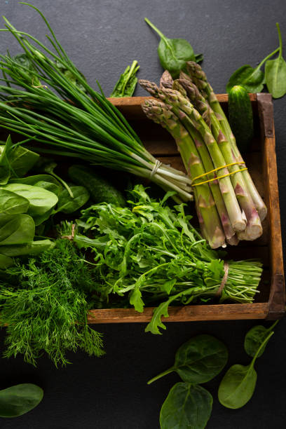 istock Green vegetable in wooden crate on dark slate background 1254340187