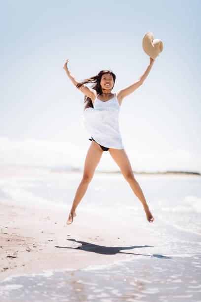 istock happiness woman jumping on the beach 1254341216