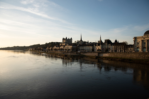 Saumur, France - 17 Feb 2019: skyline of the medieval town center with the castle and churches, along the Loire river, in Saumur, France