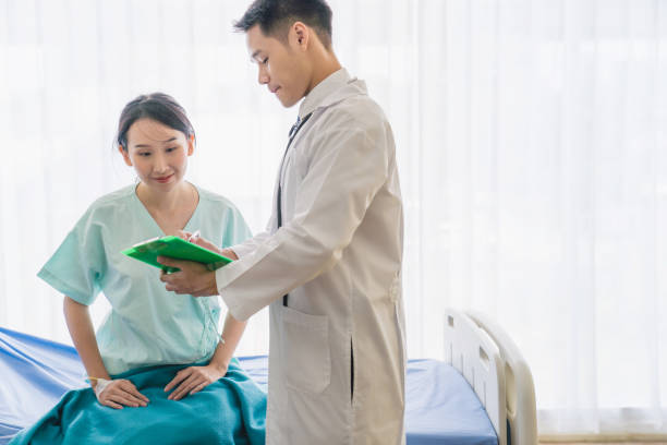 istock Young asian Doctor consulting using digital tablet working on diagnostic examination on men's health disease or mental illness, and writing on prescription record information document in clinic or hospital office medical concept 1254347581