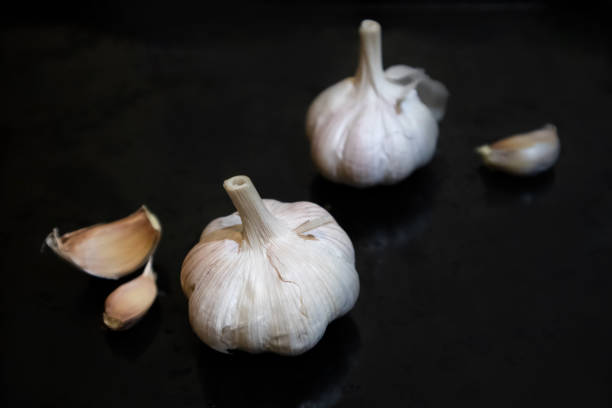 Garlic close-up product show on black background. Spice garlic clove vitamin food winter health eating