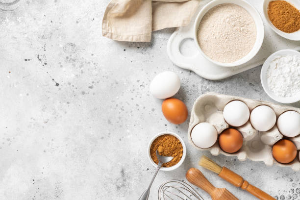 istock Ingredients for baking on a culinary background. Eggs, flour, cinnamon, sugar, soda on the kitchen table. Concept of preparation for baking. Top view with space for text 1254352943
