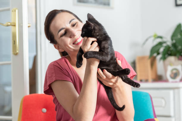istock Woman embracing black kitten 1254355693
