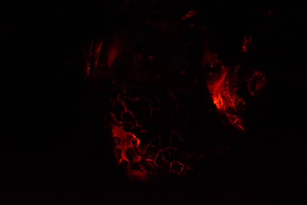 istock Burning and glowing charcoal close-up. Red coals with fire on a black background. Burning coals. 1254358782