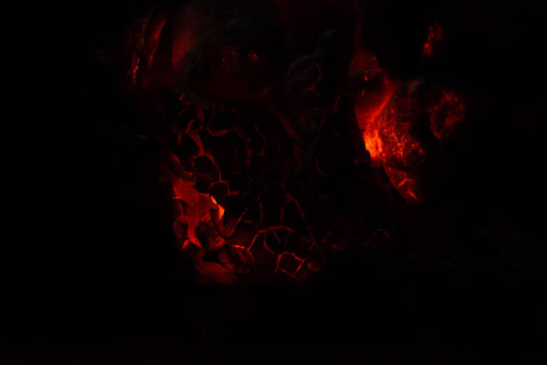 istock Burning and glowing charcoal close-up. Red coals with fire on a black background. Burning coals. 1254359631
