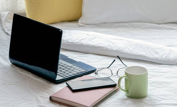 istock Work from home concept wiht laptop and supplise on white sheets in bed room. 1254360834