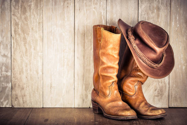 cappello da cowboy in pelle retrò wild west e vecchi stivali. foto filtrata in stile vintage - wild west boot shoe cowboy foto e immagini stock