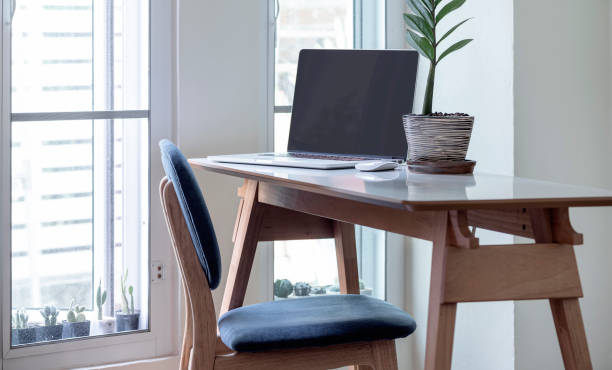 istock Blank screen laptop on wooden table in modern house. 1254361821