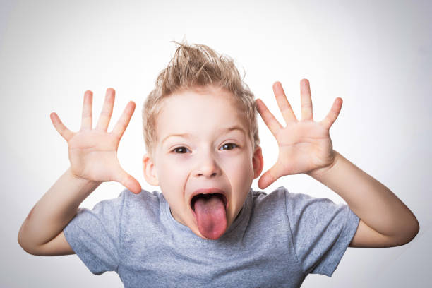 Portrait of a young boy looking through hands